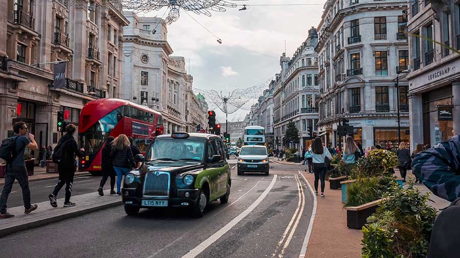 A shot of a London street with double decker bus and black cab