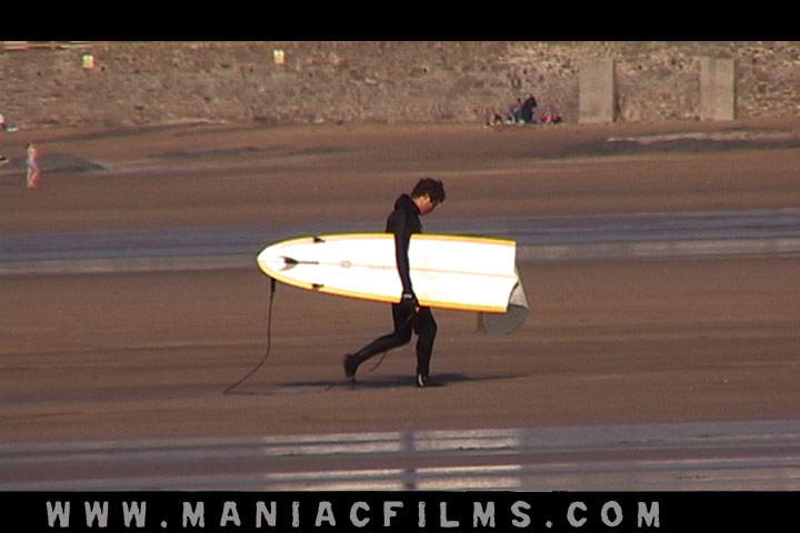 A surfer heads home with a broken board on a big swell at Croyde